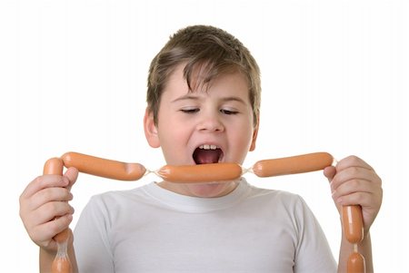 Boy with appetite bites sausages isolated in white Stock Photo - Budget Royalty-Free & Subscription, Code: 400-04766844