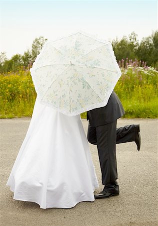 Young couple kissing hiding behind an umbrella Foto de stock - Super Valor sin royalties y Suscripción, Código: 400-04766915