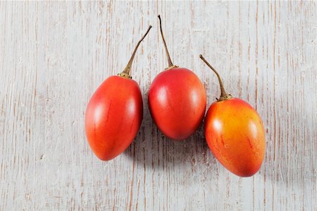 Three Tamarillo fruit (tree tomato) on white wooden background. Foto de stock - Super Valor sin royalties y Suscripción, Código: 400-04767105