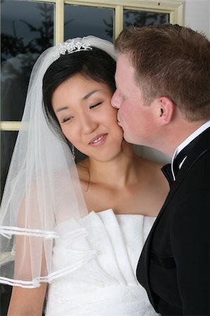 simsearch:400-05052227,k - Beautiful Asian and Causian bridal couple on their wedding day Stockbilder - Microstock & Abonnement, Bildnummer: 400-04767120