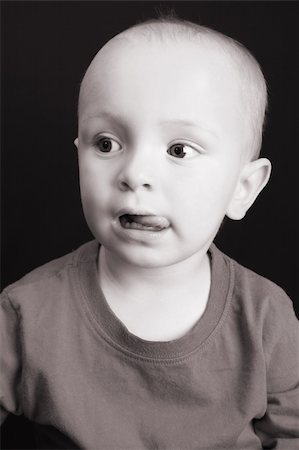 simsearch:400-05727835,k - Blond toddler against a black background with a serious expression Fotografie stock - Microstock e Abbonamento, Codice: 400-04767514