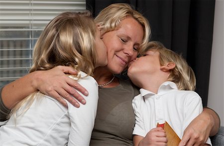 simsearch:400-05751566,k - Mother kissed by her children while reading a book to them Stock Photo - Budget Royalty-Free & Subscription, Code: 400-04767708