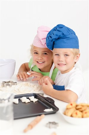 simsearch:400-05749768,k - Two little chefs preparing cookies in the kitchen and smiling at the camera Stock Photo - Budget Royalty-Free & Subscription, Code: 400-04767858