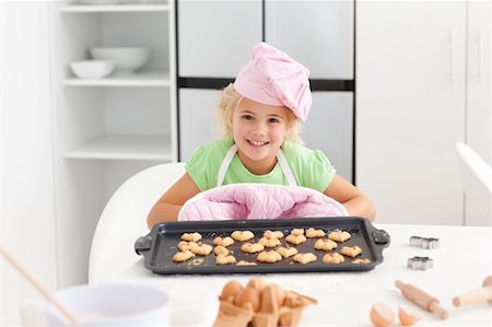 Happy little girl holding a plate with her cookies ready to eat standing in the kitchen Stock Photo - Budget Royalty-Free & Subscription, Code: 400-04767859