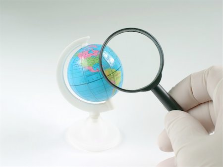 Earth globe & human hand with magnifying glass Photographie de stock - Aubaine LD & Abonnement, Code: 400-04768009