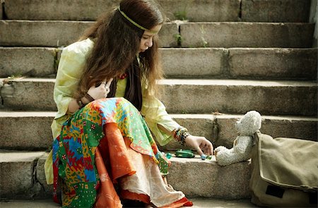 poor landscape - young female playing with hand-made toy , selective focus on eye Stock Photo - Budget Royalty-Free & Subscription, Code: 400-04768710