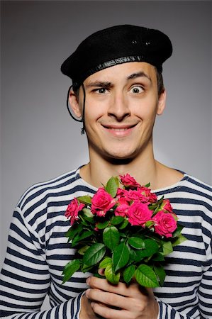 simsearch:400-05294518,k - Funny emotional romantic sailor man holding rose flowers prepared for a date Fotografie stock - Microstock e Abbonamento, Codice: 400-04768750