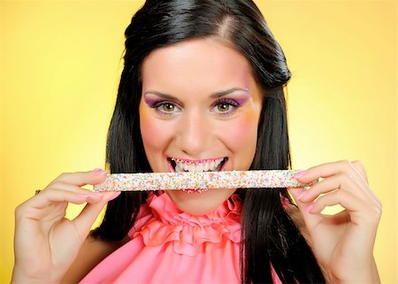 Beautiful happy woman with a hali gali sweet lollipop . yellow background Stock Photo - Budget Royalty-Free & Subscription, Code: 400-04768753