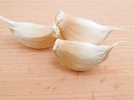 Three segments of garlic are located on a board for crushing of vegetables Stock Photo - Budget Royalty-Free & Subscription, Code: 400-04769408