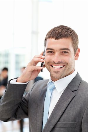 simsearch:400-04113098,k - Happy hispanic businessman on the phone while his team is working in the background Stock Photo - Budget Royalty-Free & Subscription, Code: 400-04769418