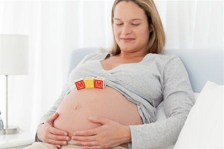 simsearch:400-04266869,k - Relaxed woman looking at mom letters on her belly and resting on a bed Stock Photo - Budget Royalty-Free & Subscription, Code: 400-04769450