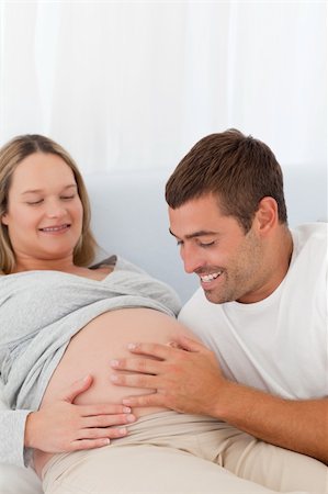 simsearch:400-04266840,k - Proud future dad touching the belly of his wife lying on the bed at home Photographie de stock - Aubaine LD & Abonnement, Code: 400-04769474