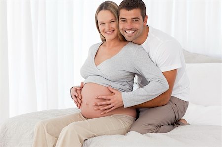 simsearch:400-04266844,k - Pregnant woman touching her belly with her husband both sitting in the bedroom Stock Photo - Budget Royalty-Free & Subscription, Code: 400-04769487