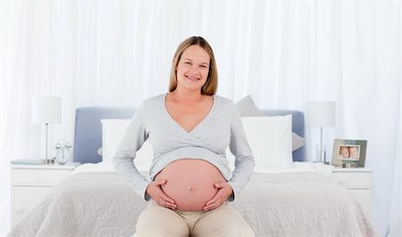 simsearch:400-04767824,k - Joyfull pregnant woman in her bedroom smiling at the camera Foto de stock - Royalty-Free Super Valor e Assinatura, Número: 400-04769514