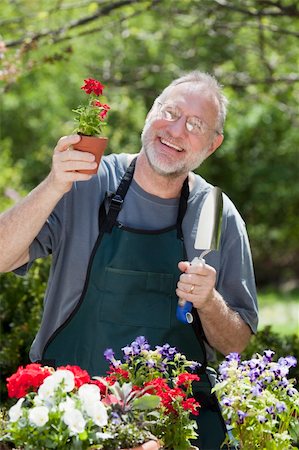 simsearch:400-04328345,k - Man smiles at the camera while gardening with potted plants outdoors. Stock Photo - Budget Royalty-Free & Subscription, Code: 400-04760077