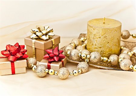 simsearch:400-05314491,k - The gold background with a Christmas candle ball chains and gift boxes. Photographie de stock - Aubaine LD & Abonnement, Code: 400-04760172
