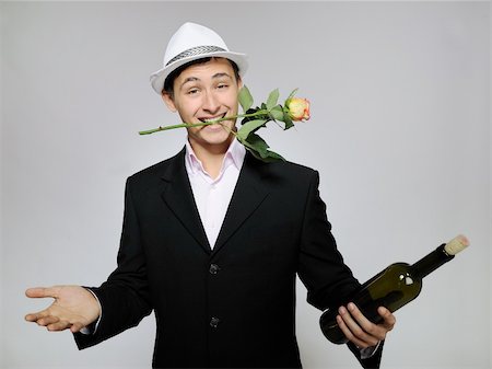 simsearch:400-04655736,k - Handsome romantic young man holding rose flower and vine bottle  prepared for a date. gray background Stockbilder - Microstock & Abonnement, Bildnummer: 400-04760434