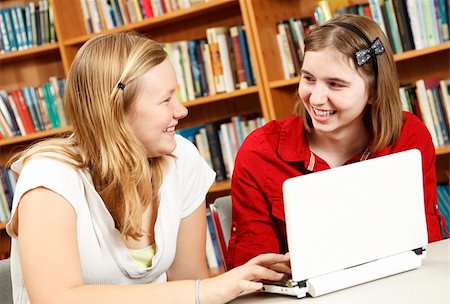 simsearch:400-04841324,k - Teen girls in the school library, discussing what they are learning online. Photographie de stock - Aubaine LD & Abonnement, Code: 400-04761449