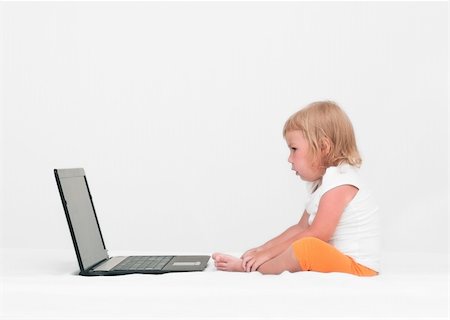 simsearch:400-04129482,k - A small child is sitting with a laptop on the bed Photographie de stock - Aubaine LD & Abonnement, Code: 400-04761990