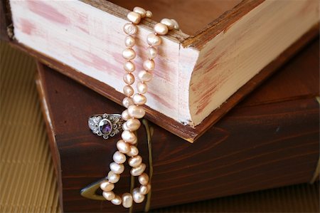 Pearls and a silver ring with a purple stone on a wooden jewellery box Stock Photo - Budget Royalty-Free & Subscription, Code: 400-04762145