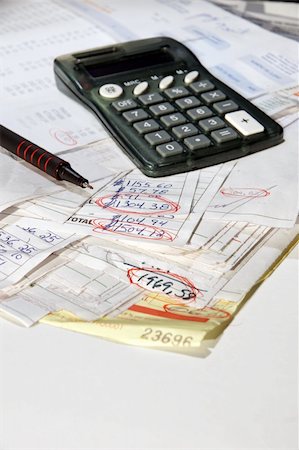 Stack of real bills invoices with calculator and red pen (focus on tip and circled amount) showing debts on white table. Fotografie stock - Microstock e Abbonamento, Codice: 400-04762606