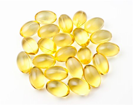 Nutritional supplement pills in warm colors and shallow depth of field. The yellow ones are vitamin E and cod liver oil. Fotografie stock - Microstock e Abbonamento, Codice: 400-04762921