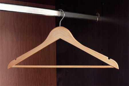 Wooden hanger hanging in an empty closet on the upper Stock Photo - Budget Royalty-Free & Subscription, Code: 400-04774005