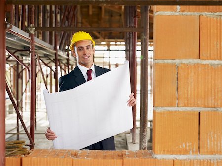 simsearch:400-04238062,k - Architect holding blueprints and looking at camera. Photographie de stock - Aubaine LD & Abonnement, Code: 400-04774002