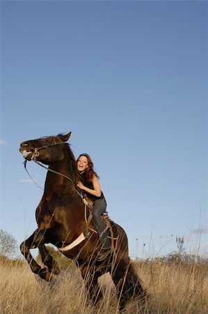 rearing horseback riding - rearing black stallion and happy young woman in a field Stock Photo - Budget Royalty-Free & Subscription, Code: 400-04774095