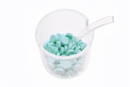 Pills in Plastic Measuring Cup on White Background Foto de stock - Super Valor sin royalties y Suscripción, Código: 400-04777210