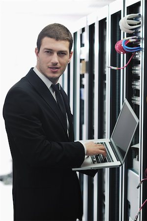 server room managers - young engeneer business man with thin modern aluminium laptop in network server room Stock Photo - Budget Royalty-Free & Subscription, Code: 400-04779226