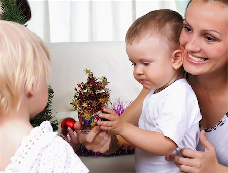 simsearch:400-09222788,k - Mum and kids sits near a christmas fur-tree Photographie de stock - Aubaine LD & Abonnement, Code: 400-04779317