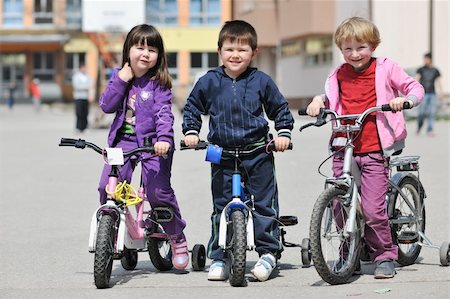 simsearch:400-04336561,k - happy childrens group learning to drive bicycle outdoor at beautiful sunny spring day Fotografie stock - Microstock e Abbonamento, Codice: 400-04779350