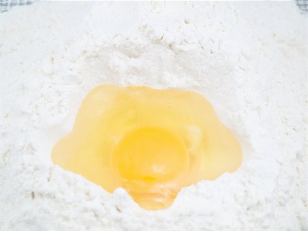 Egg is hammered into a flour hill which is on a kitchen table Stock Photo - Budget Royalty-Free & Subscription, Code: 400-04779441