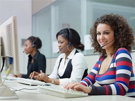 simsearch:400-04785322,k - multiethnic group of female customer service representatives talking on the phone, with woman looking at camera. Horizontal shape, side view Stock Photo - Budget Royalty-Free & Subscription, Code: 400-04779973