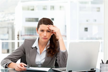 simsearch:400-04287211,k - Worried businesswoman working at her desk with laptop and folder Stock Photo - Budget Royalty-Free & Subscription, Code: 400-04772254