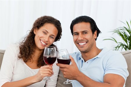simsearch:400-04663577,k - Happy couple drinking red wine sitting on the sofa at home Stock Photo - Budget Royalty-Free & Subscription, Code: 400-04772266