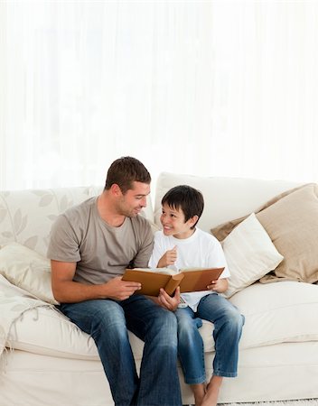 simsearch:400-04268918,k - Adorable boy looking at a photo album with his father on the sofa at home Stockbilder - Microstock & Abonnement, Bildnummer: 400-04772269