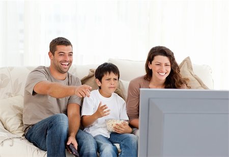 family on sofa popcorn - Family laughing while watching television together in the living-room Stock Photo - Budget Royalty-Free & Subscription, Code: 400-04772271