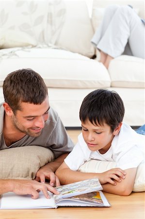 simsearch:400-04193532,k - Attentive father reading a book with his son lying on the floor at home Stock Photo - Budget Royalty-Free & Subscription, Code: 400-04772283