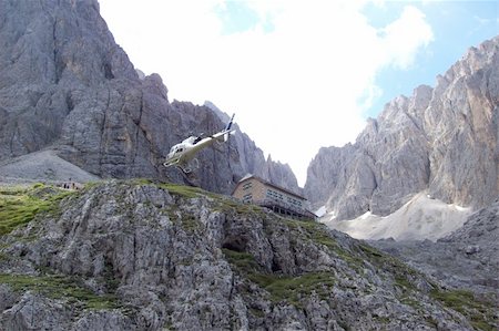 With a helicopter landed in the Dolomites.The ideal position for mountain friends, the best point to start for easy as well difficult hiking or climbing tours as for exemple the point the Oscar Schuster route to the top of the "Sassopiatto" (m. 3083) or the normal climbing route to the "Sassolungo" (m. 3183). Photographie de stock - Aubaine LD & Abonnement, Code: 400-04772320