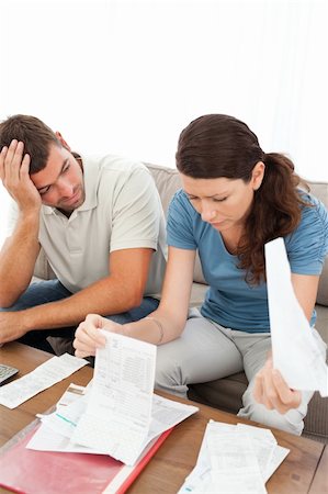 simsearch:400-05746763,k - Stressed man and woman looking at their bills in the living room at home Stock Photo - Budget Royalty-Free & Subscription, Code: 400-04773008