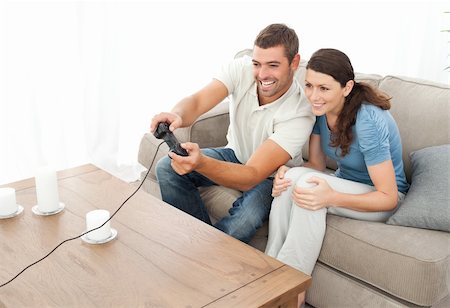 simsearch:400-04199147,k - Attentive couple playing video game together in the living room at home Foto de stock - Royalty-Free Super Valor e Assinatura, Número: 400-04773003