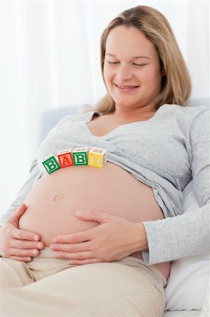 simsearch:400-04767824,k - Portrait of a future mom with baby letters on her belly and smiling at the camera Foto de stock - Royalty-Free Super Valor e Assinatura, Número: 400-04773028