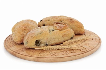 Olive bread roll selection on a carved wooden board with ears of wheat, over white background. Stock Photo - Budget Royalty-Free & Subscription, Code: 400-04773442