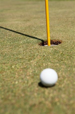 Golf ball laying on the green with flag still in hole Stock Photo - Budget Royalty-Free & Subscription, Code: 400-04785550