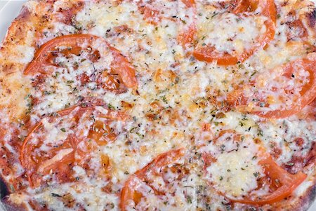 simsearch:400-05172569,k - Tomato pizza with tomatoes and spicery closeup Photographie de stock - Aubaine LD & Abonnement, Code: 400-04788435