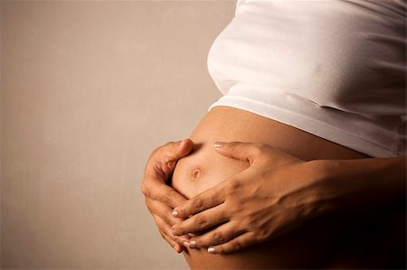 simsearch:400-05084530,k - Pregnant woman holding her belly  over dark background Foto de stock - Super Valor sin royalties y Suscripción, Código: 400-04789786