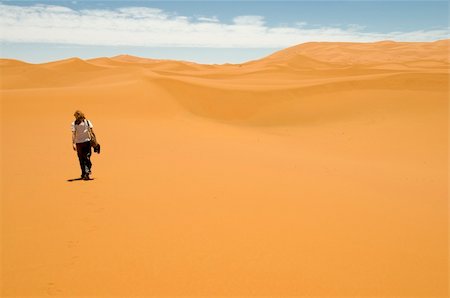 simsearch:400-06100677,k - Woman walking alone among the sand dunes of the Sahara desert. Best of Morocco. Photographie de stock - Aubaine LD & Abonnement, Code: 400-04781831