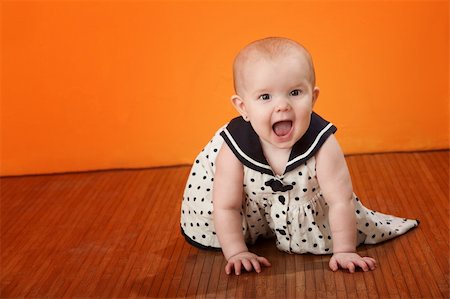 funny naughty pictures babies people - A cute baby with polka dot dress crawls on a wooden floor Stock Photo - Budget Royalty-Free & Subscription, Code: 400-04783208